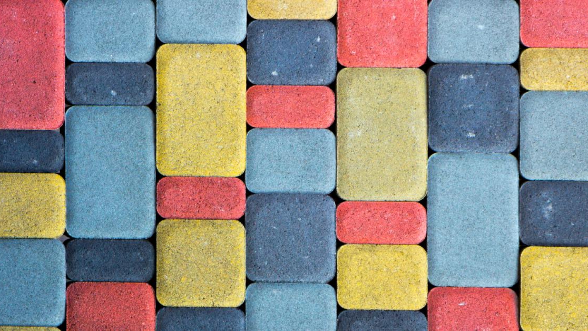 A colored concrete path with slabs in varying sizes and colors. The colors include red, yellow, and blue.