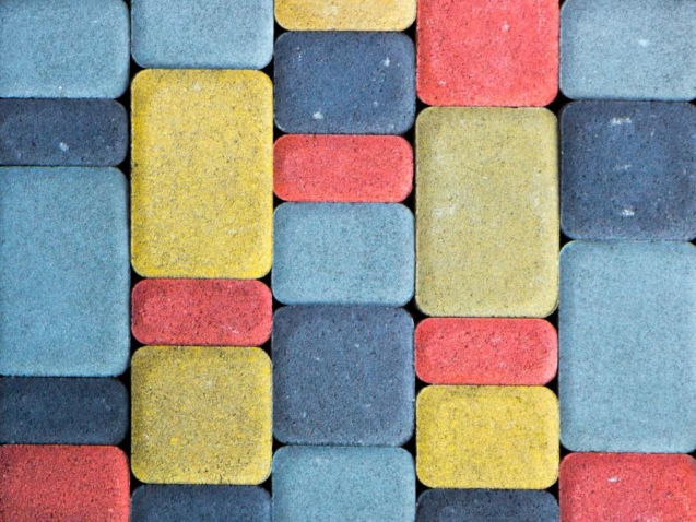 A colored concrete path with slabs in varying sizes and colors. The colors include red, yellow, and blue.