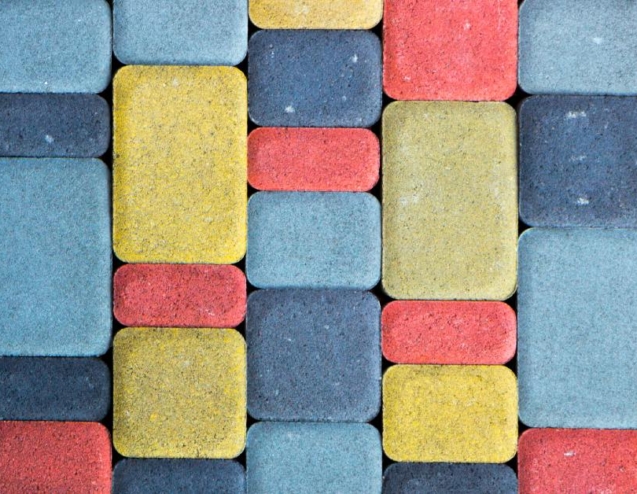 A colored concrete path with slabs in varying sizes and colors. The colors include red, yellow, and blue.