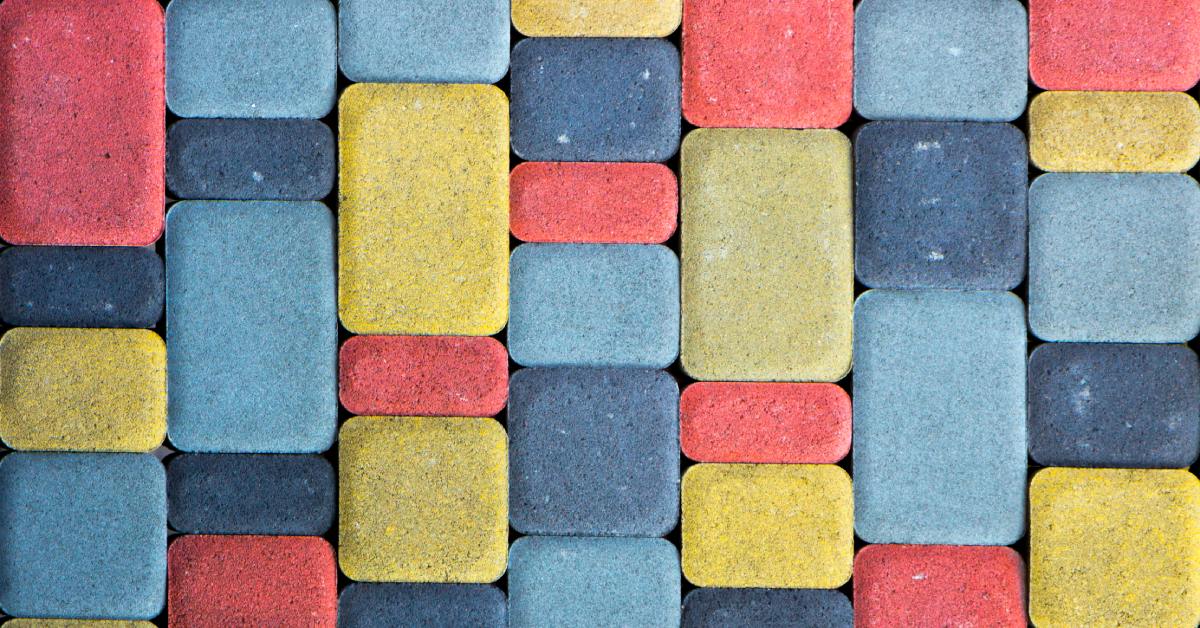 A colored concrete path with slabs in varying sizes and colors. The colors include red, yellow, and blue.